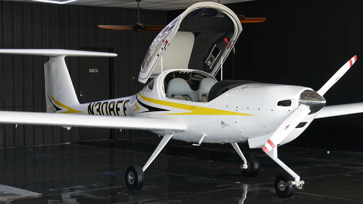 Diamond DA20-C1 in the hangar with its forward-hinged bubble canopy raised