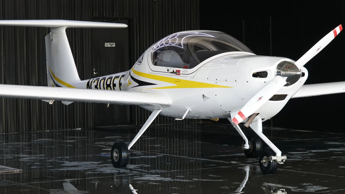 Diamond DA20-C1 from the front right in the hangar, canopy closed and propeller upright