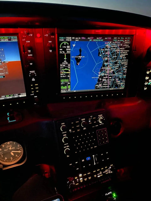 A glass cockpit with the moving map display lit at night