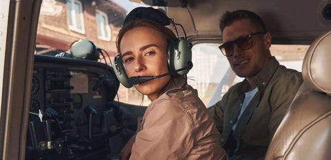 A smiling student pilot in a headset beside her instructor in the cockpit